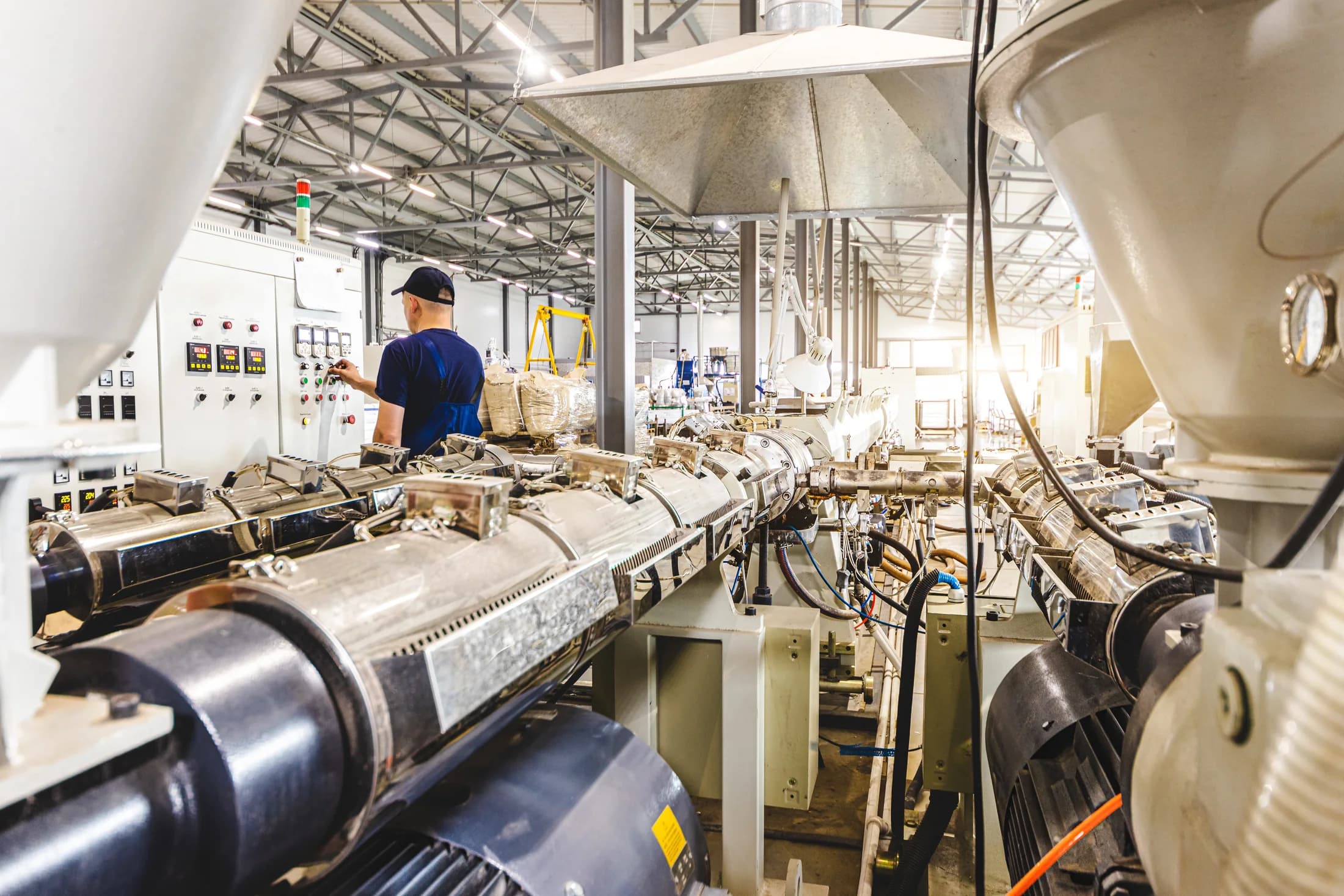 A technician inspecting machinery on a plastic extrusion production line